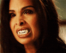 a woman with red eyes and white teeth is smiling