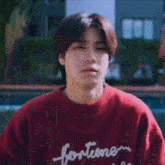 a man wearing a red sweater with the word fortune written on it