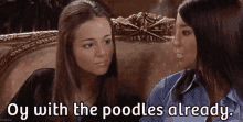 two women are sitting next to each other on a couch and one of them is talking to the other .