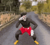 a man in a mickey mouse costume is standing on a road
