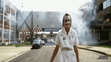 a nurse is walking down a street in front of an emergency room