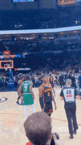 a man taking a picture of a basketball game with a number 48 on his back