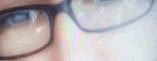 a close up of a person wearing glasses and looking at a computer screen .