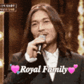 a man in a suit is singing into a microphone with the words royal family written above him