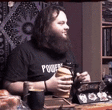 a man with a beard wearing a black shirt that says power on it