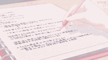 someone is writing in a notebook with a pink pencil