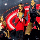 a little boy is singing into a microphone while a woman holds a camera