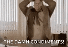 a man in a suit and tie is holding his hands to his head and screaming .