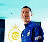 a man in a blue shirt with snickers on the sleeves smiles