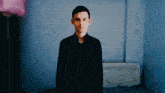 a man in a black shirt is standing in a room