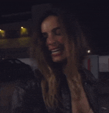 a blurry photo of a woman in a leather jacket and bra