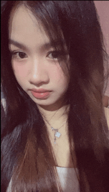 a close up of a woman 's face with a necklace on her neck