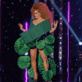 a woman with red hair is wearing a green dress made of paper