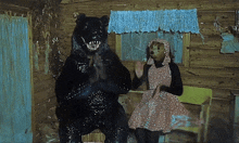 a woman in a pink dress is sitting next to a bear