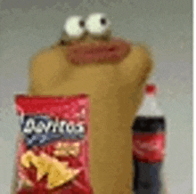 a bag of doritos is sitting next to a bottle of coke .