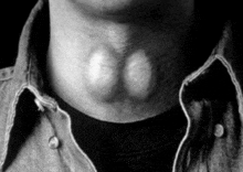 a close up of a man 's neck with a black shirt on