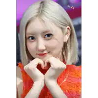 a woman making a heart shape with her hands in front of her face