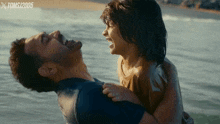 a man is holding a little girl in his arms with xtoms 2005 written on the bottom