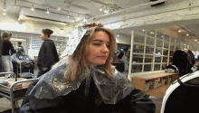 a woman is getting her hair dyed in a hair salon