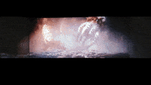 a blurred image of a person 's hand reaching out in a dark room