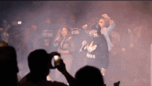 a man is taking a picture of a group of people in a crowd .