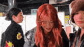 a woman with red hair is wearing a brown hat and a black jacket