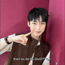 a young man pointing at his face with the words " kien es de lu owo " written below him