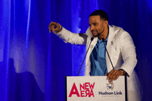 a man stands behind a podium that says new era hudson link on it