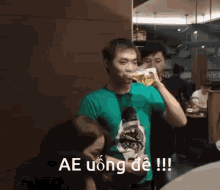 a man in a green shirt is drinking from a glass with the words ae uong de written on the bottom