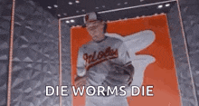 a baseball player is in a box with the words `` die worms die '' written above him .