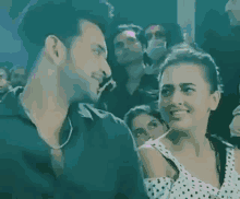 a man and a woman are dancing together in a crowd of people .