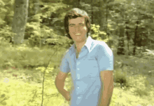 a man in a blue shirt is standing in a field