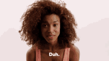 a woman with curly hair says duh in front of her