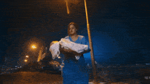 a woman sits on a ledge holding a blanket over a child with a caption in a foreign language