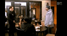 a man in a white hoodie with the letter m on the bottom right