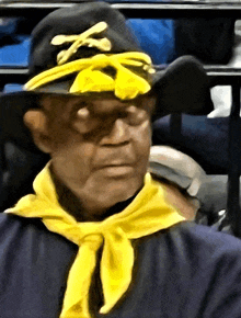 a man wearing a black hat and a yellow scarf