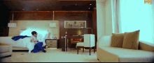 a man sits on the floor in a hotel room with a couch