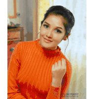 a woman wearing an orange sweater with nm pradeep fotofolio on the bottom