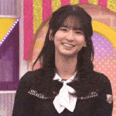 a girl wearing a black shirt and a white tie is smiling .