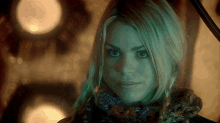 a woman wearing a scarf looks at the camera