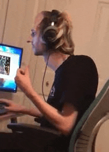 a man wearing headphones is sitting in a chair in front of a computer .