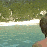 a man is looking out over a body of water with mountains in the background