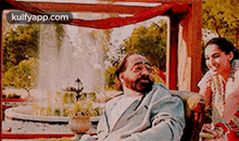 a man and a woman are sitting on a couch .