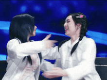 two women in white jackets are hugging each other