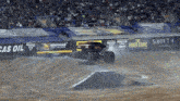a monster truck is doing a trick on a dirt track