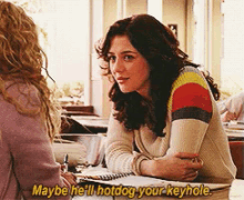 a woman is sitting at a table talking to another woman who is saying " maybe he 'll hotdog your keyhole "