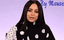 a woman wearing a black and white polka dot sweater with the words by mouse written above her