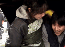 a man and a woman are standing next to each other and the woman has a green apron on