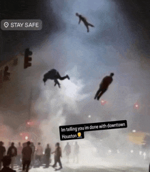 a group of people flying through the air with a stay safe sticker