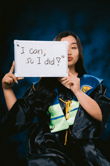 a woman in a graduation cap and gown holds up a sign that says " i can so i did "